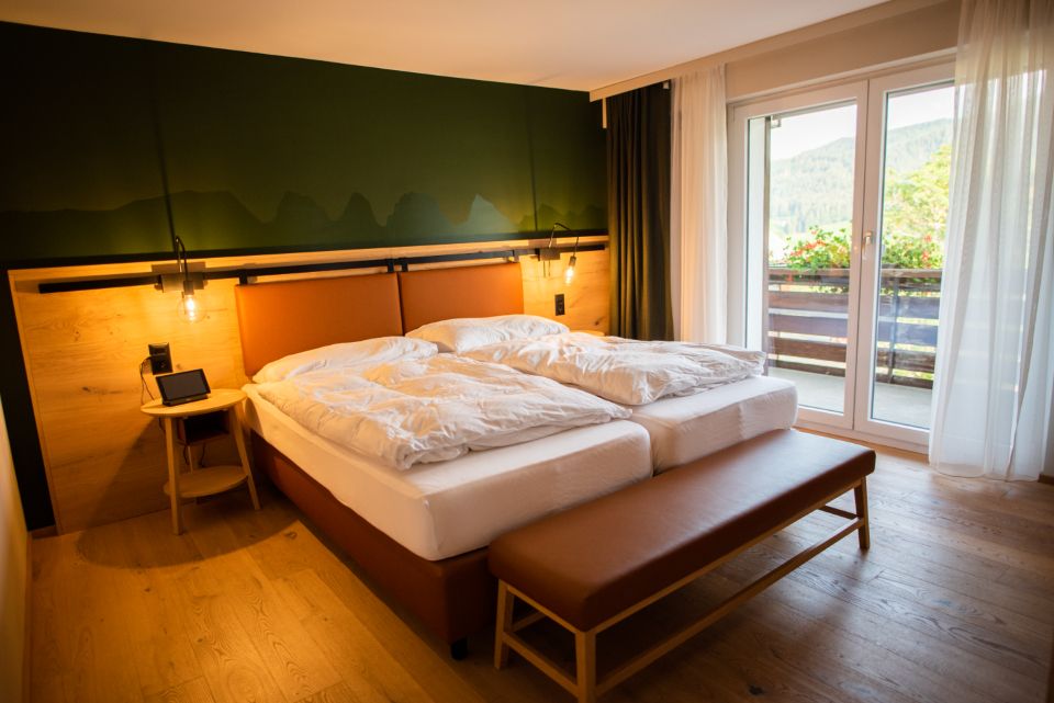 A guest room with a large bed and soft lighting